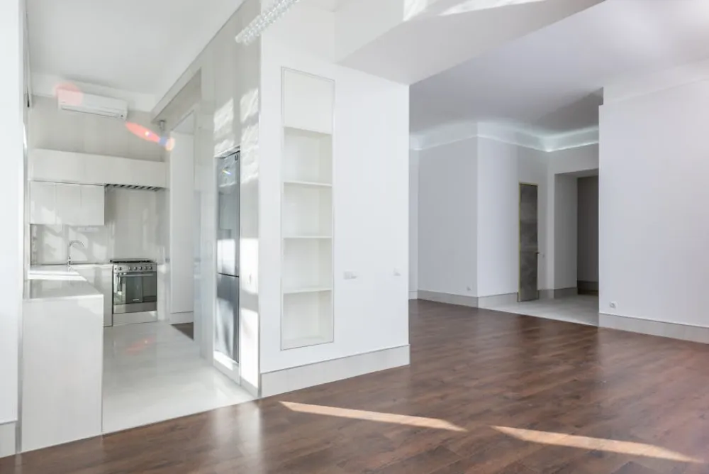 Spacious modern interior featuring an open kitchen and living area with elegant wooden flooring, ideal for contemporary 